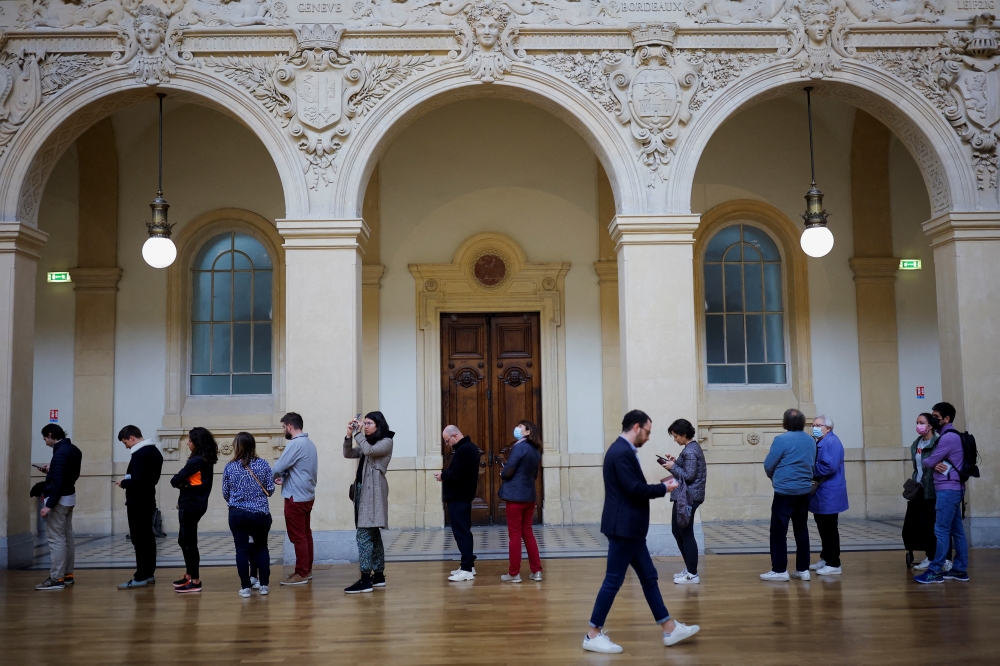 People queue to vote in the second round of the 2022 French presidential election at a polling station in Lyon, France, April 24, 2022. (Reuters/Stephane Mahe)