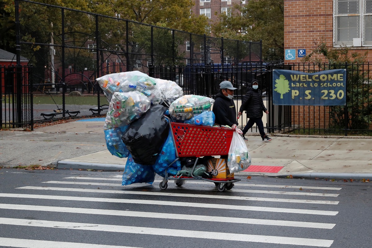 A man with a protective face mask walks with recyclables in a shopping cart as the spread of coronavirus disease (COVID-19) continues in the borough of Brooklyn in New York, U.S., October 13, 2020. REUTERS/Shannon Stapleton/File Photo

