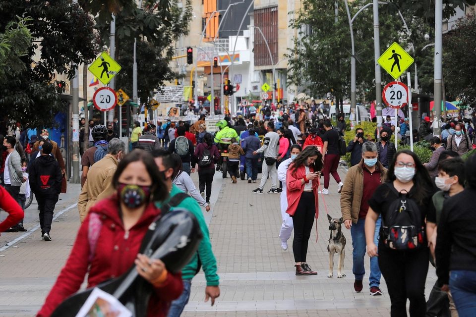 People wearing face masks walk down a street before the start of a mandatory total isolation decreed by the mayor's office, amidst an outbreak of the coronavirus disease (COVID-19), in Bogota, Colombia January 7, 2021. REUTERS/Luisa Gonzalez