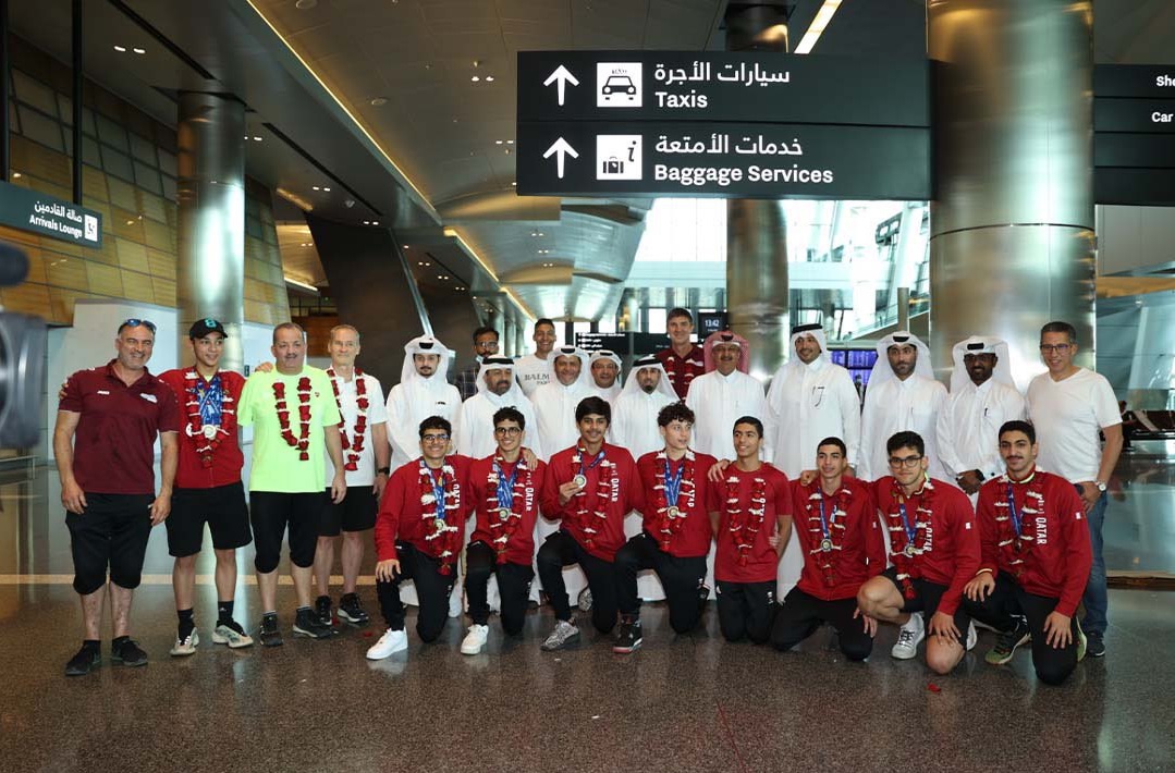 Qatar swimming team’s players and officials pose for a photograph on their arrival in Doha, yesterday. 