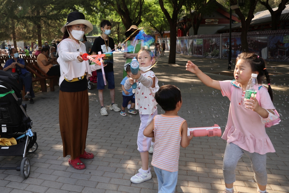 Children play with bubbles at a park during Dragon Boat festival holiday, following the coronavirus disease (COVID-19) outbreak, in Beijing, China June 4, 2022. Reuters/Tingshu Wang