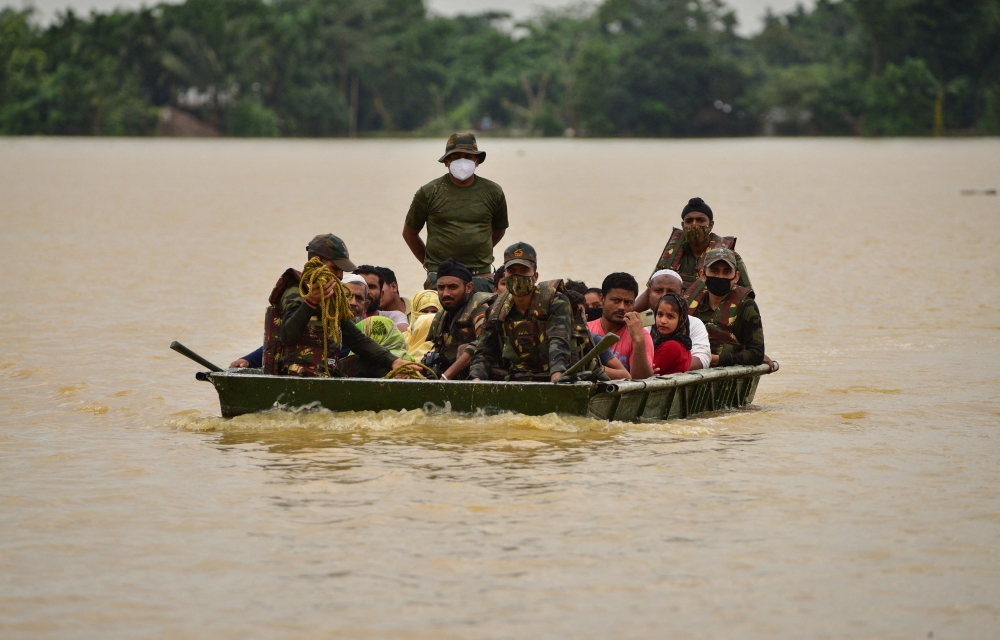 Indian Army soldiers evacuate people from flooded area to a safer place after heavy rains at a village in Hojai district, in the northeastern state of Assam, India, June 18, 2022. REUTERS/Anuwar Hazarika