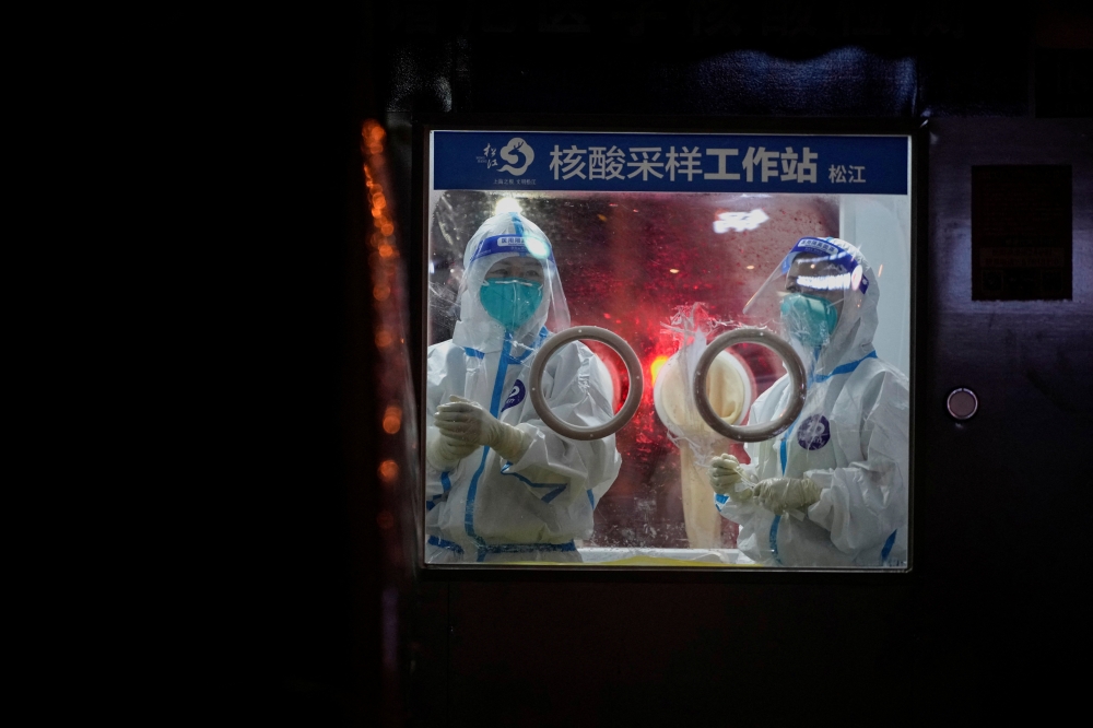 Medical workers in protective suits stand at a nucleic acid testing site in Shanghai, China July 7, 2022. REUTERS/Aly Song