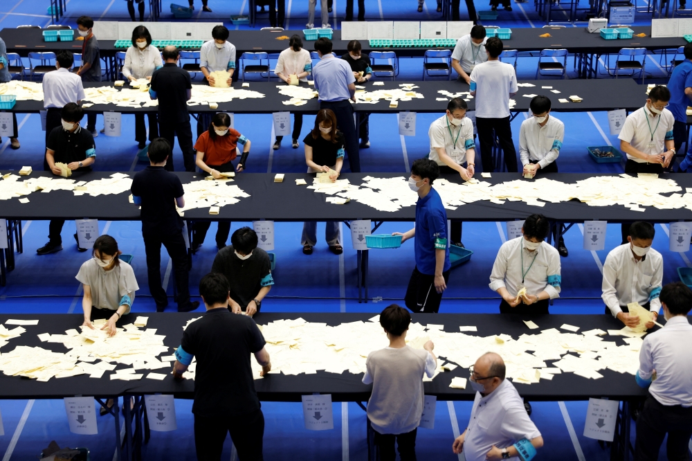 Election officials count votes at a ballot counting centre for Japan's upper house election in Tokyo, Japan, July 10, 2022. (REUTERS/Issei Kato)