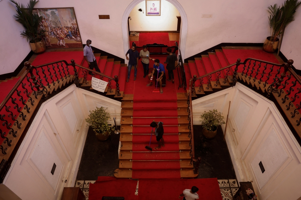 A man sweeps the stairs inside the President's house after President Gotabaya Rajapaksa fled, amid the country's economic crisis, in Colombo, Sri Lanka July 14, 2022. REUTERS/Adnan Abidi