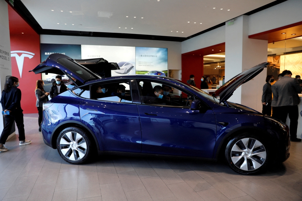 Visitors wearing face masks check a China-made Tesla Model Y sport utility vehicle (SUV) at the electric vehicle maker's showroom in Beijing, China January 5, 2021. REUTERS/Tingshu Wang/File Photo/File Photo