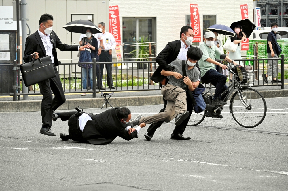 The alleged assassin of former Japanese Prime Minister Shinzo Abe is tackled by police officers in Nara, western Japan, on July 8, 2022. (Reuters)

