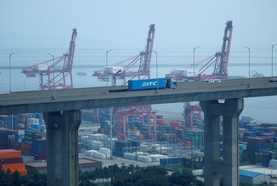 A truck carrying a shipping container travels past cranes at Pyeongtaek port in Pyeongtaek, South Korea, July 9, 2020. REUTERS/Kim Hong-Ji/File Photo


