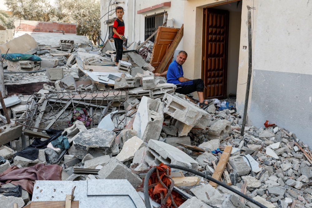 Hesham, one of four disabled Palestinian siblings from Shamalakh family, sits at the rubble of their home after it was destroyed in an Israeli air strike in Gaza City on August 6, 2022. (Reuters/Ibraheem Abu Mustafa)

