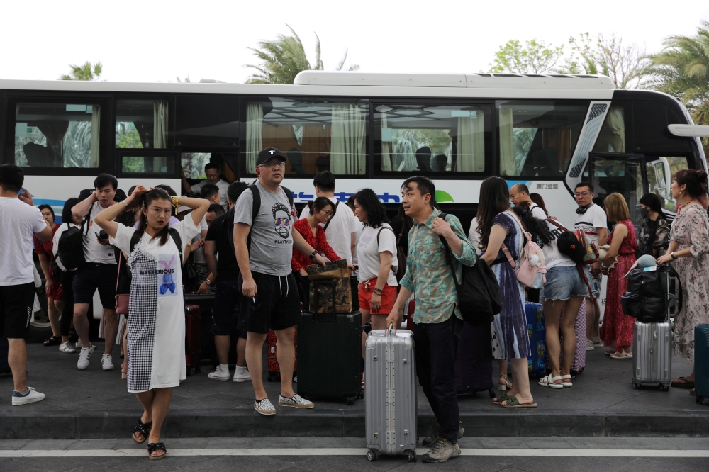 People get off a coach at an entrance of Atlantis Sanya resort in Sanya, Hainan province, China November 25, 2020. Picture taken November 25, 2020. REUTERS/Tingshu Wang/File Photo