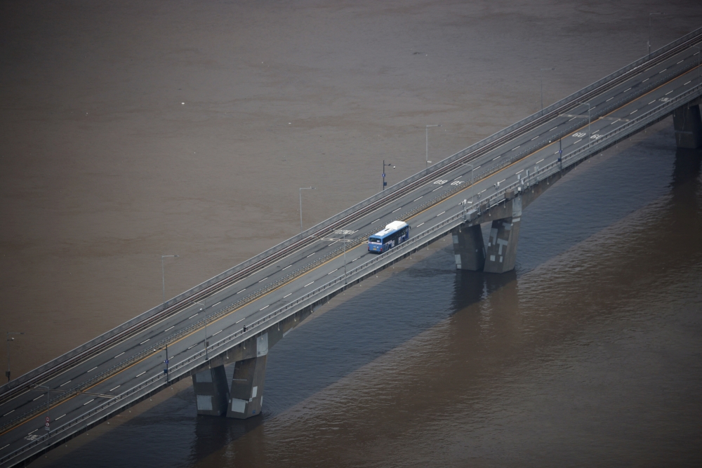 A bus travels on a bridge over flooded Han river by torrential rain in Seoul, South Korea, August 11, 2022. REUTERS/Kim Hong-Ji