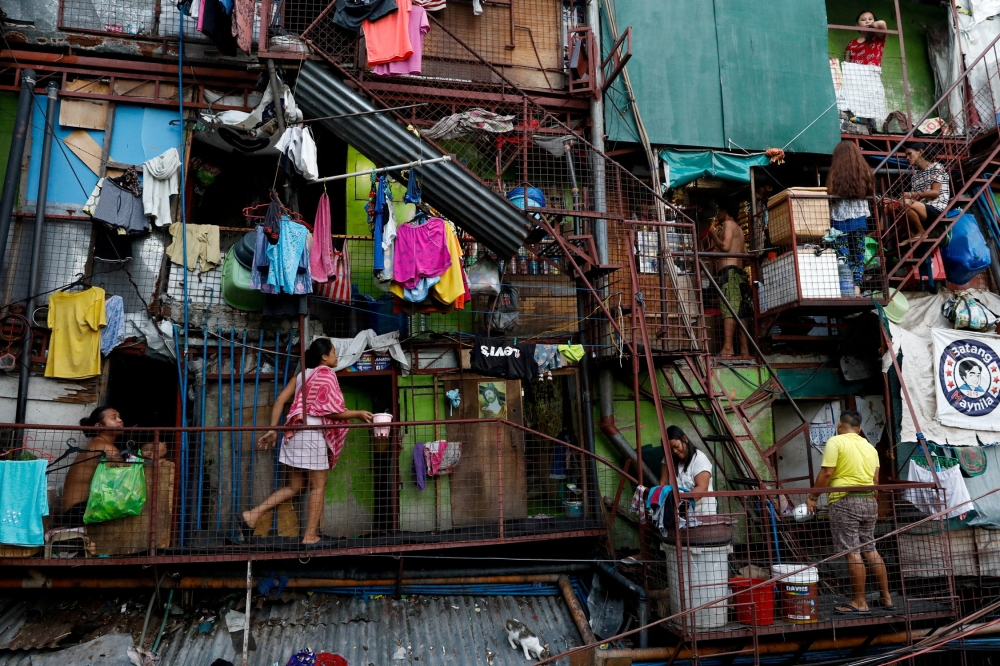 Residents of a small apartment building do house chores outside their units, amid the lockdown to contain the coronavirus disease (COVID-19), in a slum area in Tondo, Manila, Philippines, May 4, 2020. REUTERS/Eloisa Lopez/File Photo/File Photo
