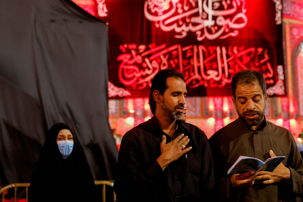 Shi'ite Muslim pilgrims read prayers as they commemorate the Arbaeen, in Kerbala, Iraq September 28, 2021. Reuters/Abdullah Dhiaa Al-Deen/File Photo