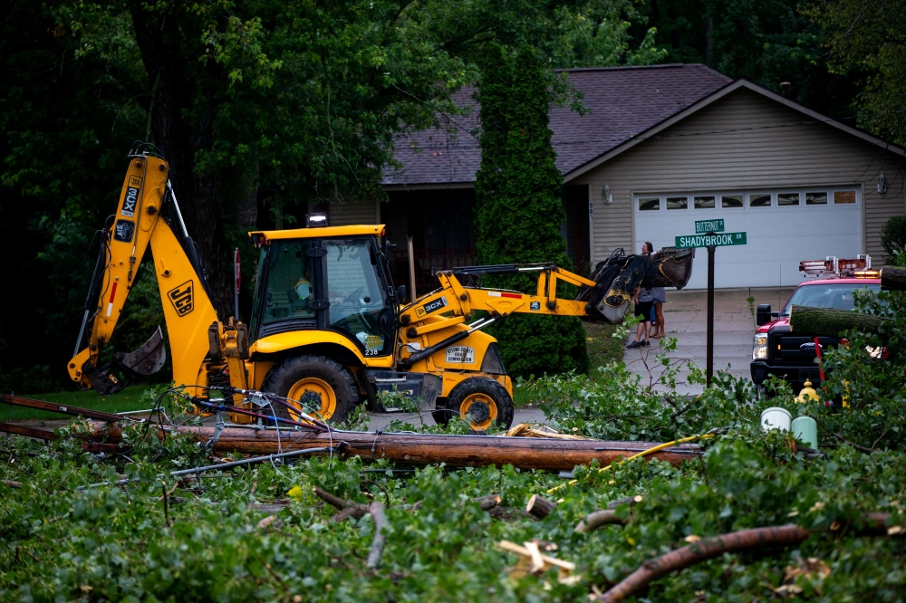 Fallen tree limbs are cleared after thunderstorms and high winds downed power lines and closed roads in Holland, Michigan, on August 29, 2022. Cody Scanlan/USA Today Network via REUTERS. 