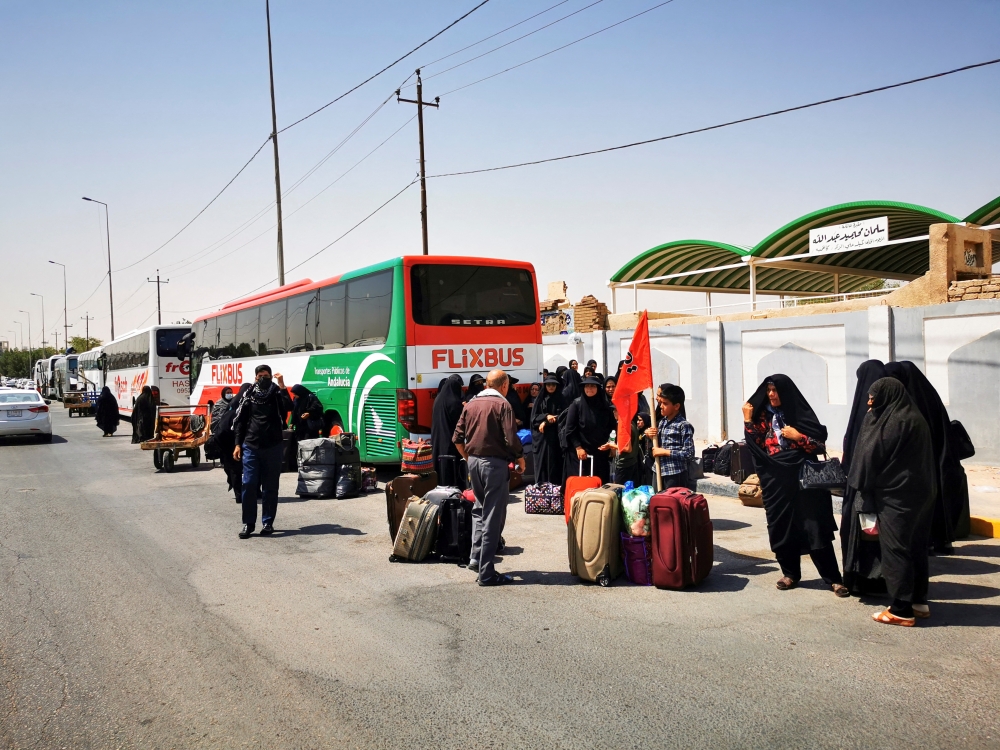 Iranian Shi'ite pilgrims gather around cars to leave Iraq, after political crisis, in Najaf, Iraq, on August 30, 2022. REUTERS/Ahmed Saeed 