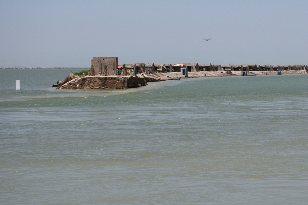 A view of houses on an embankment that partially eroded amid floodwater, following rains and floods during the monsoon season in Bhan Syedabad, Pakistan, September 3, 2022. (REUTERS/Yasir Rajput)