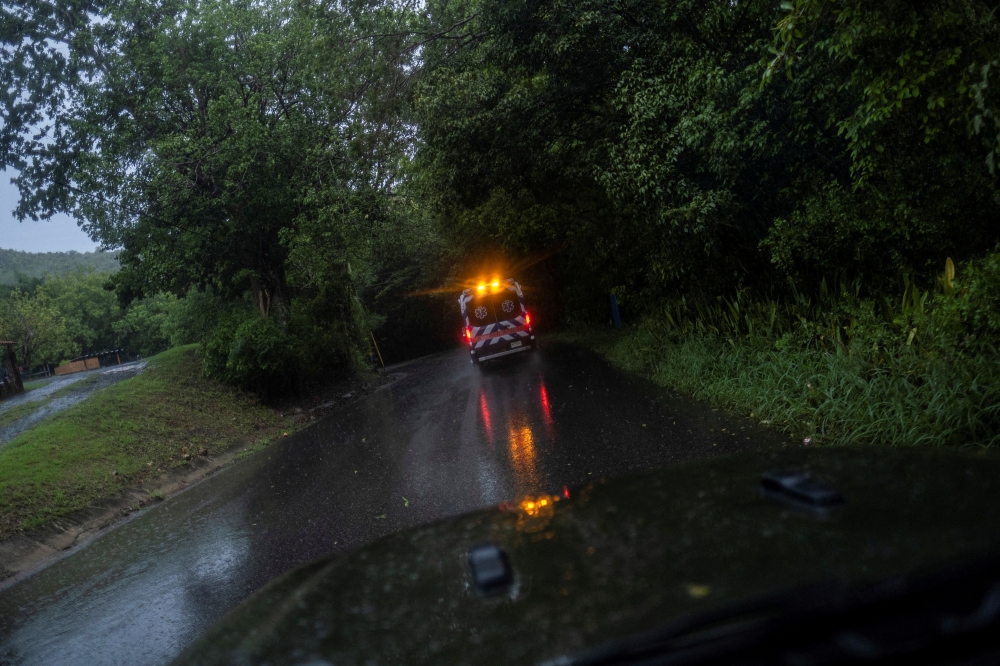 An ambulance drives through a wet rural road as Hurricane Fiona and its heavy rains approaches in Guayanilla, Puerto Rico, on September 18, 2022. (REUTERS/Ricardo Arduengo)