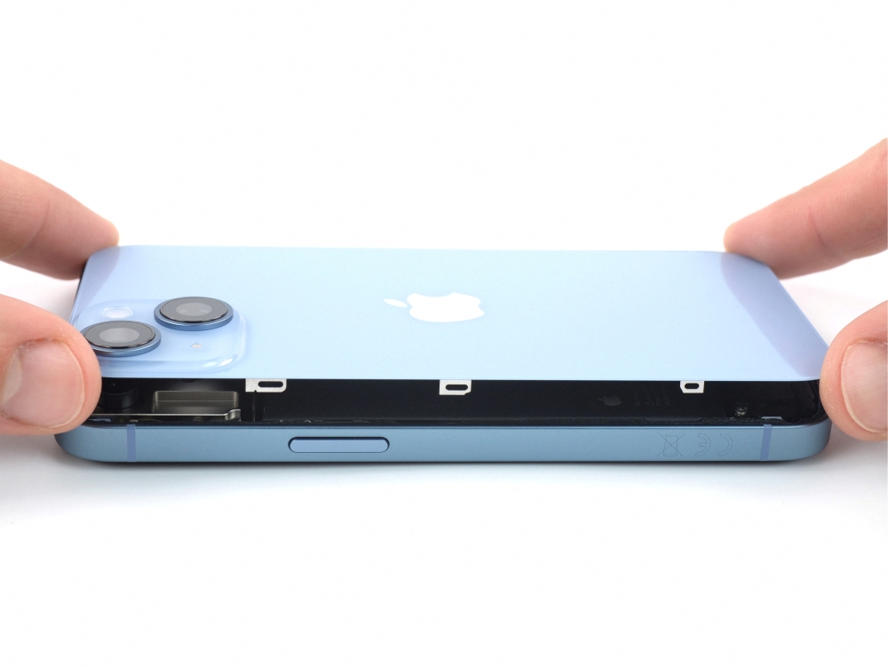 An employee of electronics repair firm iFixit is seen removing the back of an Apple iPhone 14 in San Luis Obispo, California, US in this undated handout picture provided to Reuters on September 19, 2022. (Courtesy of iFixit/Handout via REUTERS)