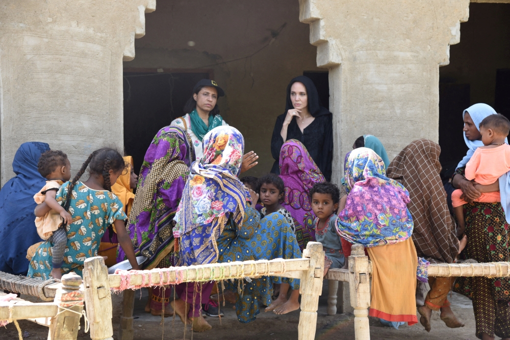 Hollywood actress and UN humanitarian Angelina Jolie listens to displaced women following rains and floods during the monsoon season, in village Ibrahim Chandio, Dadu, Pakistan, on September 20, 2022. (IRC/Saima Javaid via REUTERS) 