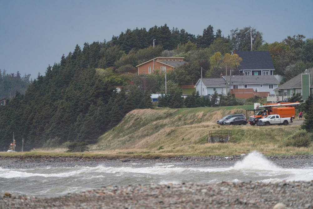 Waves crash ashore as vehicles watch during the arrival of Hurricane Fiona in Stephenville, Newfoundland, Canada, on September 24, 2022. REUTERS/John Morris