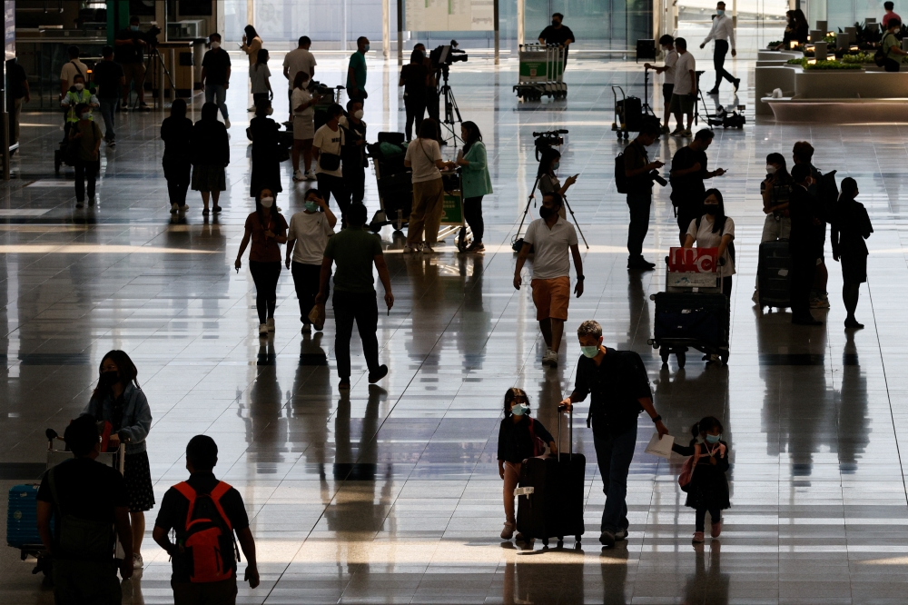 Travellers arrive at the Hong Kong International Airport on the first day the COVID hotel quarantine has been scrapped, in Hong Kong, China September 26, 2022. REUTERS/Tyrone Siu