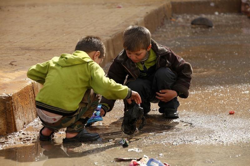 File Photo: Children remove trash blocking the drains in the Al Inzarat district in Aleppo, on February 17, 2013. (REUTERS/Hamid Khatib)