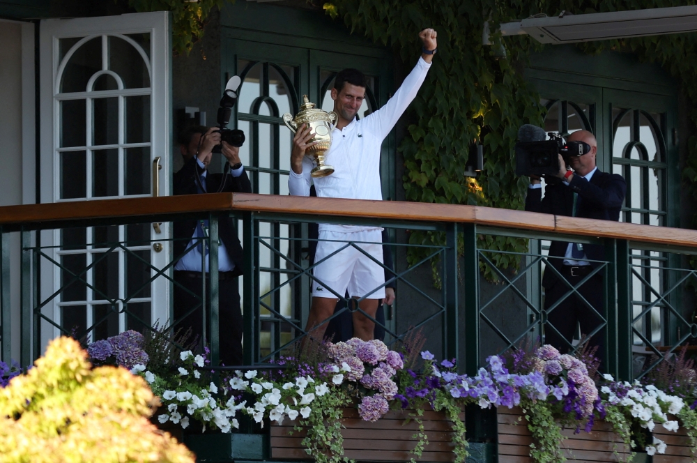 July 10, 2022 Serbia's Novak Djokovic celebrates with the trophy on the balcony after winning the men's singles final against Australia's Nick Kyrgios REUTERS/Matthew Childs/File Photo