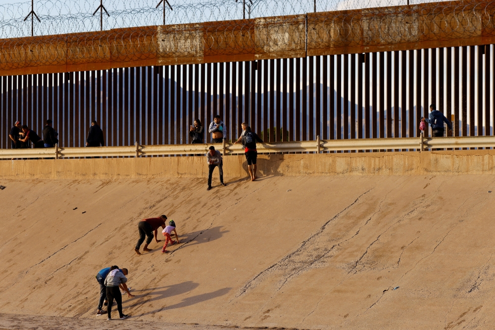 File Photo: Asylum-seeking migrants, mostly from Venezuela, walk out of the Rio Bravo river after crossing it to turn themselves in to US Border Patrol agents. (REUTERS/Jose Luis Gonzalez)