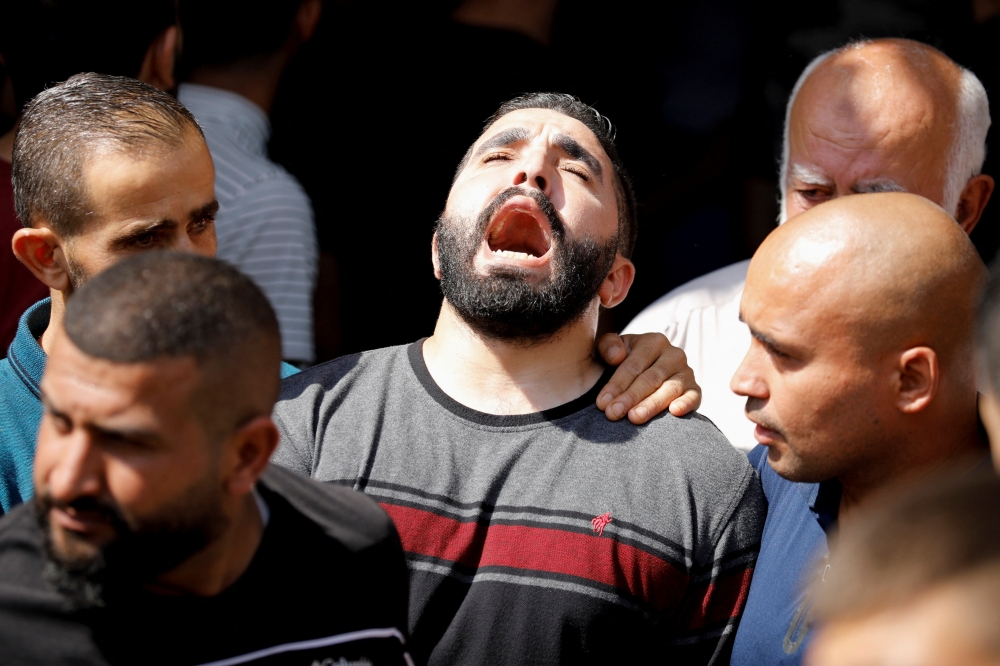 The brother of Palestinian Ahmad Daraghmeh (19), who was killed by Israeli forces, mourns during his funeral in Jenin in the Israeli-occupied West Bank on October 8, 2022. REUTERS/Raneen Sawafta