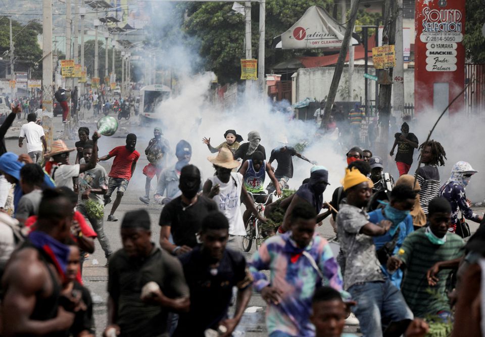 People run while police fire tear gas during a protest demanding the resignation of Haiti's Prime Minister Ariel Henry after weeks of shortages, in Port-au-Prince, Haiti, on October 10, 2022. REUTERS/Ralph Tedy Erol