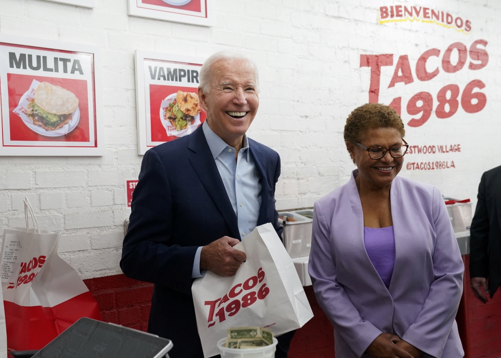 US President Joe Biden and Rep. Karen Bass (D-CA) react during visit to a taco shop in Los Angeles, California, US, on October 13, 2022. REUTERS/Kevin Lamarque