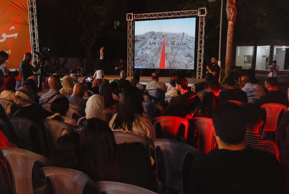 Palestinians watch the sixth edition of the Red Carpet Film Festival, at a newly innovated theatre in Gaza City, October 13, 2022. Reuters/Ibraheem Abu Mustafa