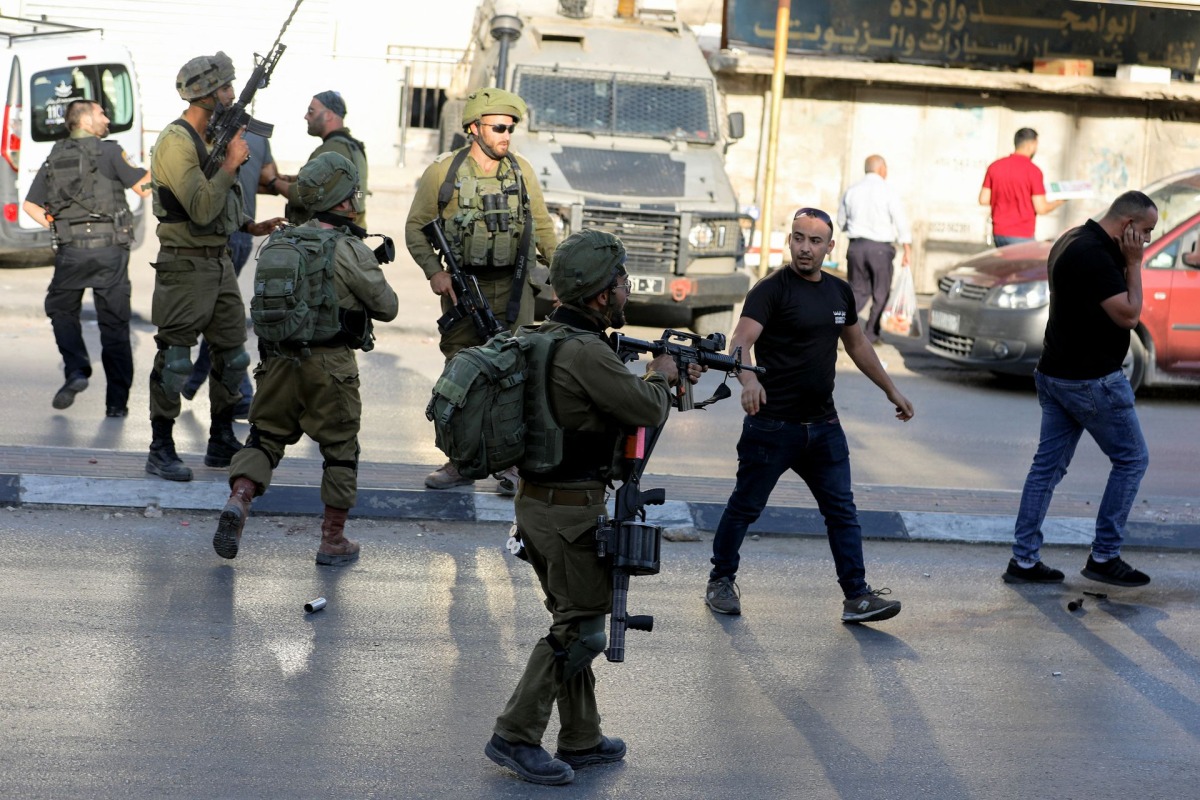 File Photo: Israeli soldiers outside a Palestinian shop in Huwara, West Bank, May 26, 2022. (REUTERS/Raneen Sawafta)