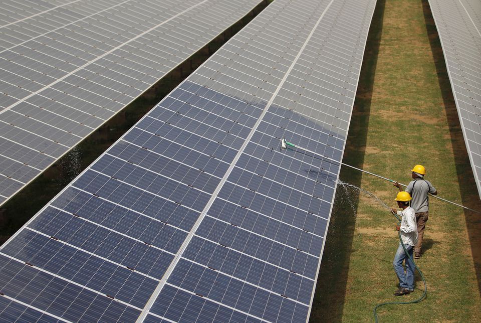 Workers clean photovoltaic panels inside a solar power plant in Gujarat, India, on July 2, 2015.  File Photo / Reuters
