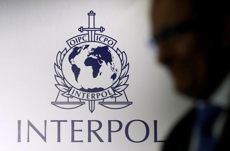 A man passes an Interpol logo during the handing over ceremony of the new premises for Interpol's Global Complex for Innovation, a research and development facility, in Singapore, on September 30, 2014.  File Photo / Reuters