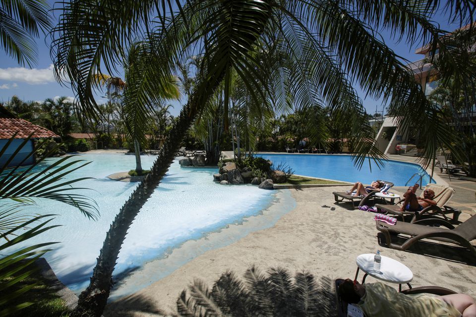 Tourists sunbathe near a pool in a hotel in Heredia, Costa Rica, on March 18, 2020.  File Photo / Reuters
