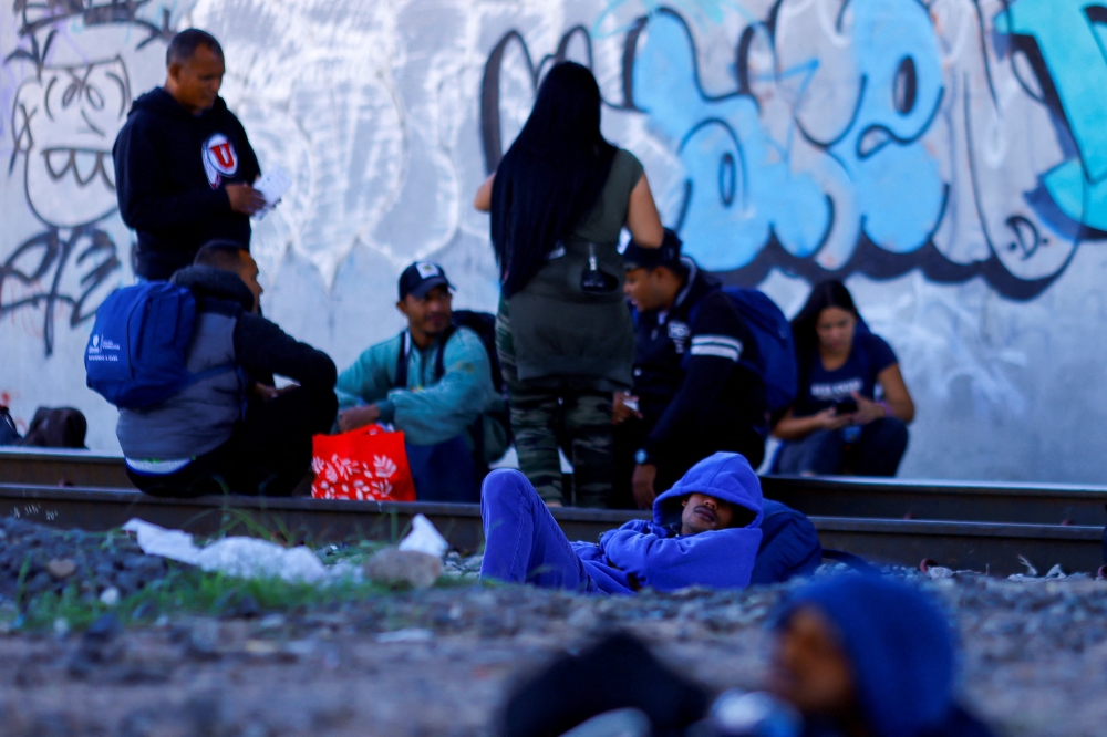 Venezuelan migrants, some expelled from the US to Mexico under Title 42 and others who have not crossed yet, stand near the Paso del Norte International border bridge, in Ciudad Juarez, Mexico, on October 21, 2022. REUTERS/Jose Luis Gonzalez