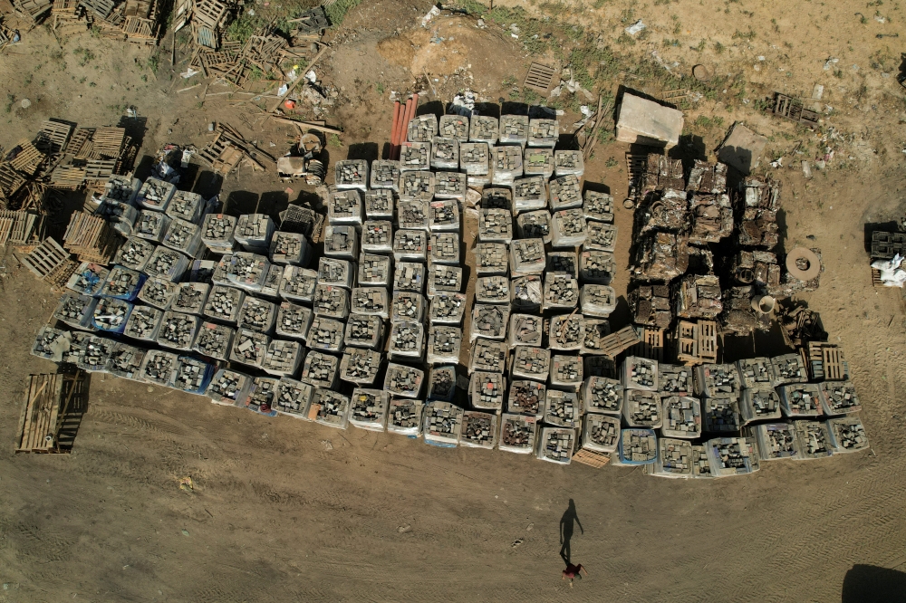 A Palestinian worker walks near broken batteries collected for sale and export, in Gaza Strip October 16, 2022. Reuters/Mohammed Salem
 