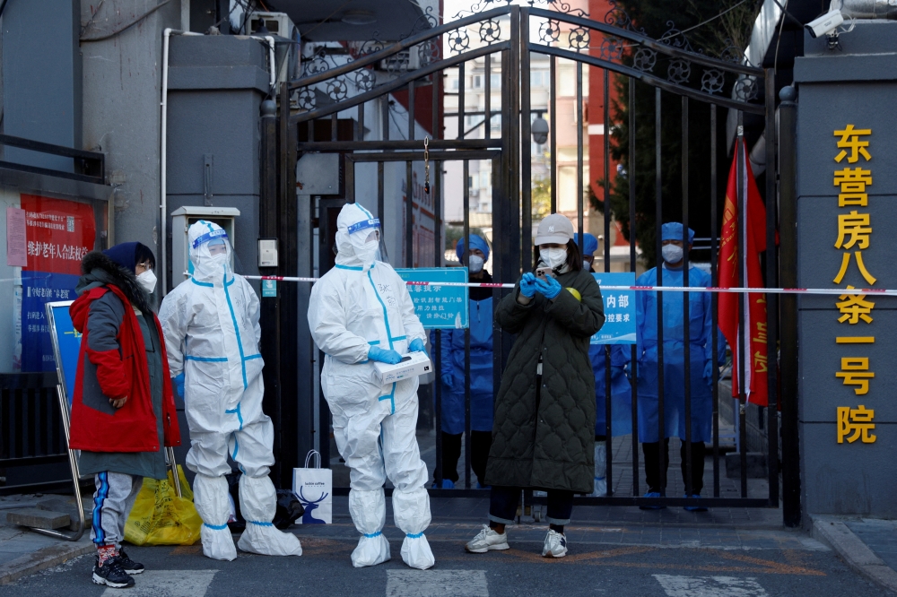 Security personnel in protective suits stand at the gate of a residential compound that is under lockdown as outbreaks of coronavirus disease (COVID-19) continue in Beijing, October 22, 2022. REUTERS/Thomas Peter/File Photo