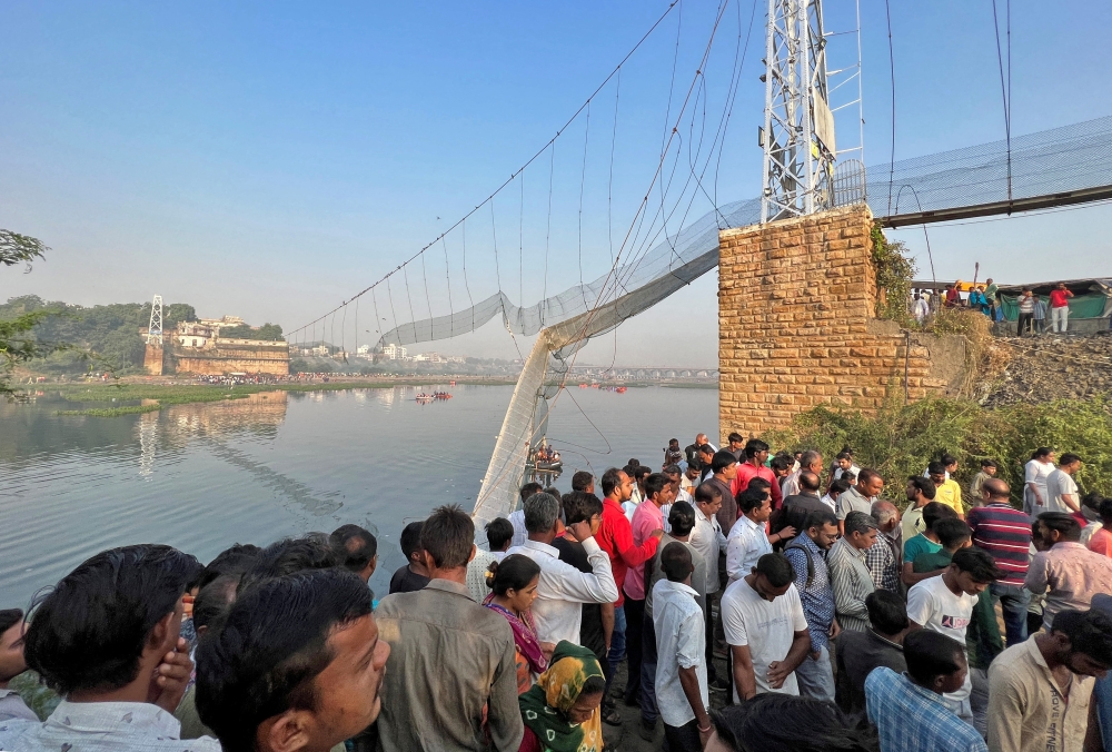 People gather as rescuers search for survivors after a suspension bridge collapsed in Morbi town in the western state of Gujarat, India, October 31, 2022. Reuters/Stringer
