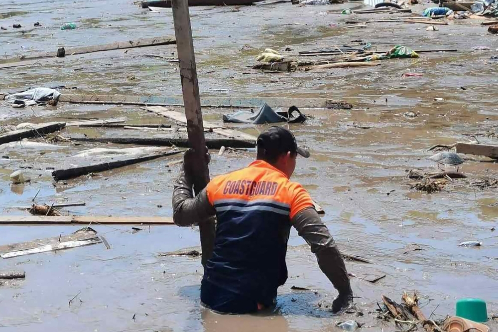 This handout photo taken on October 30, 2022 and released by the Philippine Coast Guard on October 31 shows a rescue worker using a makeshift pole as they conduct search operations in Datu Odin Sinsuat, Maguindanao province, after Tropical Storm Nalgae hit the region. Photo by Handout / Philippines Coast Guard (PCG) / AFP) / 