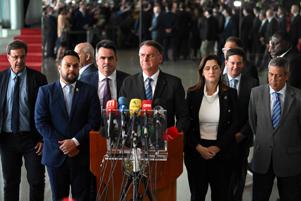 Brazilian President Jair Bolsonaro (C) makes a statement for the first time since Sunday's presidential run-off election, at Alvorada Palace in Brasilia, on November 1, 2022.  (Photo by EVARISTO SA / AFP)