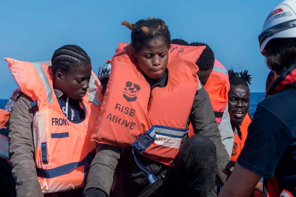 This photo taken on November 3, 2022 and handout on November 5, 2022 by German-flagged NGO Mission Lifeline shows migrants preparing to get on board the 