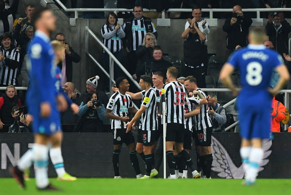 Newcastle United's English midfielder Joe Willock celebrates scoring his team's first goal with teammates during the English Premier League football match between Newcastle United and Chelsea at St James' Park in Newcastle-upon-Tyne, north east England on November 12, 2022. (Photo by ANDY BUCHANAN / AFP)