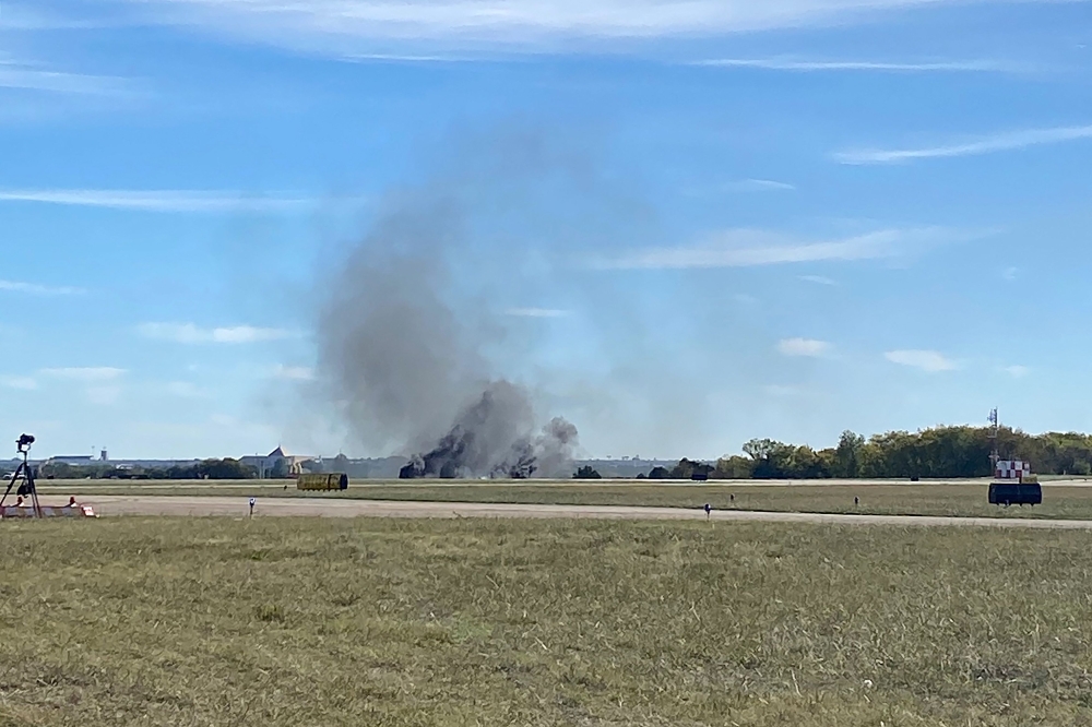 This image obtaimned from the twitter account @GollyItsMollie, shows smoke rising from the crash after two planes collided mid-air during the Wings Over Dallas Airshow at Dallas Executive Airport, in Dallas, Texas, on November 12, 2022. (Photo by Handout / @GollyItsMollie / AFP)