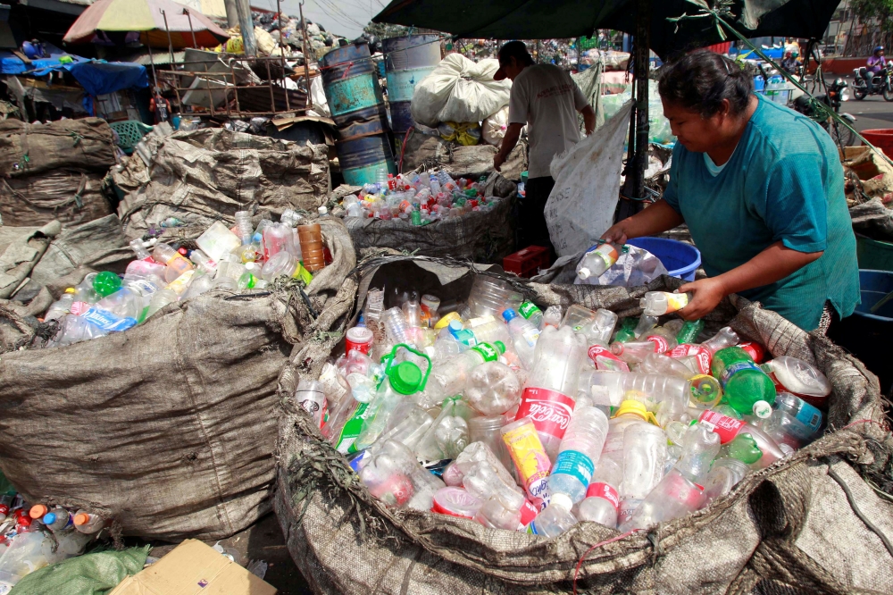 People sort through plastic bottles they collected and are about to sell at a junk shop in Manila March 10, 2015. REUTERS/Romeo Ranoco/File Photo