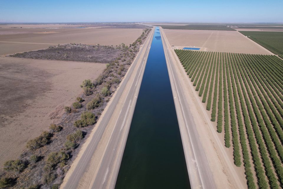 The dried out Arroyo Pasajero Creek is seen alongside an aqueduct in Huron, California, U.S. on October 25, 2022. REUTERS/Nathan Frandino