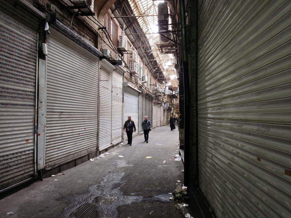 People pass shops which were closed following the recent riots and the call of protesters to close the markets, in Tehran Bazaar, in Tehran, Iran November 16, 2022. WANA (West Asia News Agency) via REUTERS