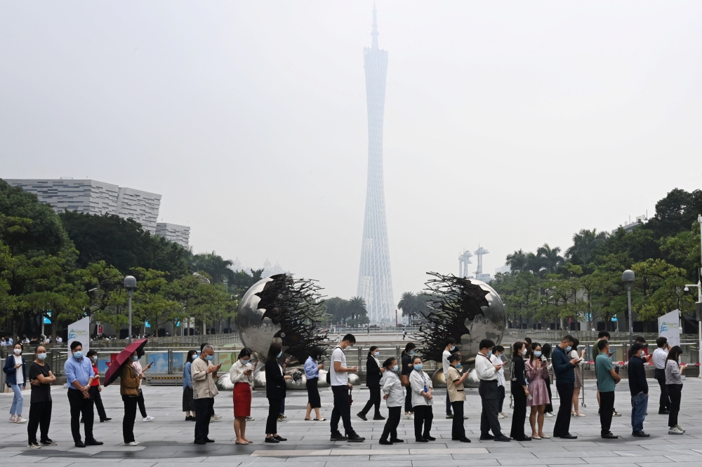 People line up to get tested for the coronavirus disease (COVID-19) at a nucleic acid testing site, on Flower City Square in Guangzhou, Guangdong province, China November 16, 2022. cnsphoto via Reuters
