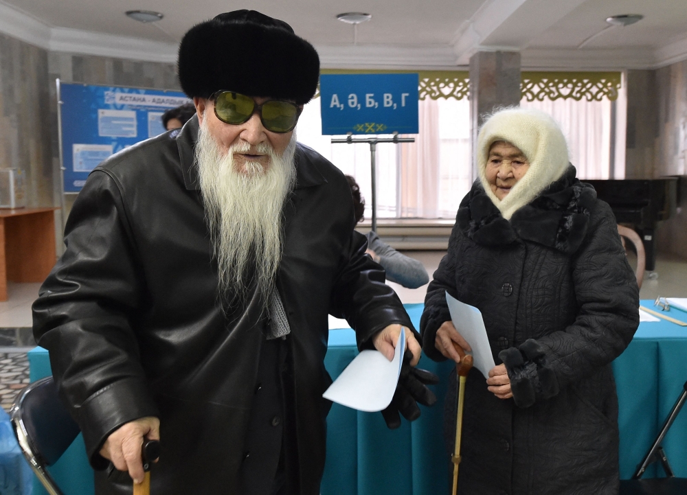 People vote at a polling station during Kazakhstan's presidential elections in Astana on November 20, 2022. - Kazakhstan holds a snap presidential vote on November 20 expected to cement incumbent Kassym-Jomart Tokayev's grip on power, months after deadly unrest spurred a historic power shift in the Central Asian country. (Photo by Vyacheslav OSELEDKO / AFP)